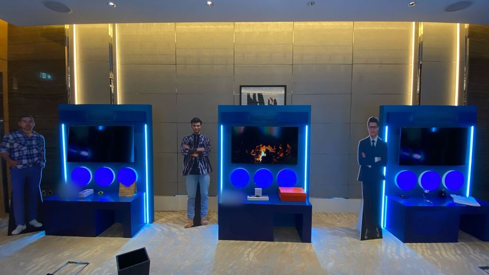 Three lit activation booths with screens and display desks