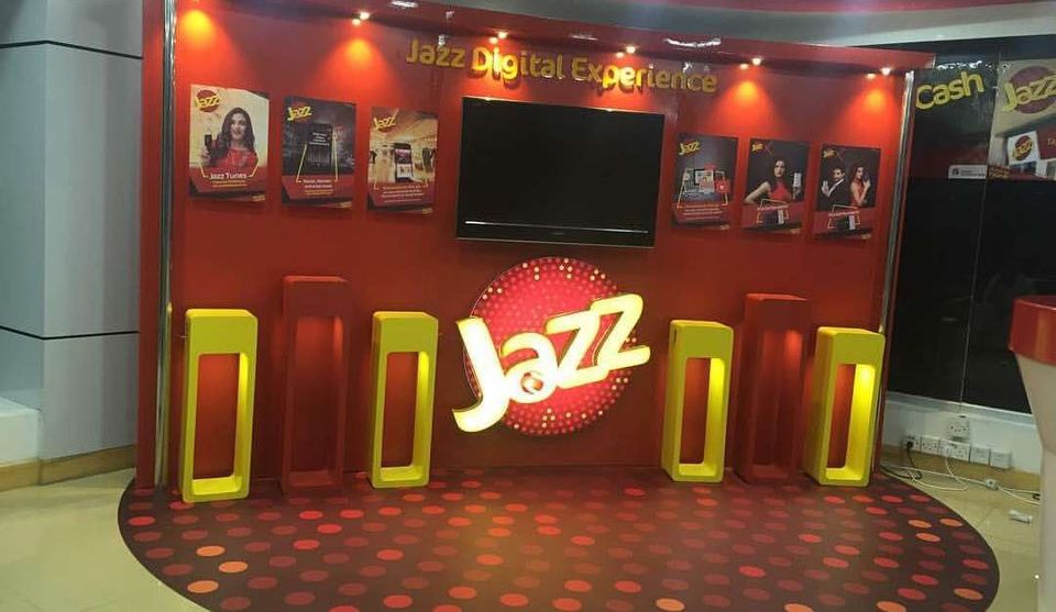 Jazz Digital Experience brand wall with a lit logo and display plinths